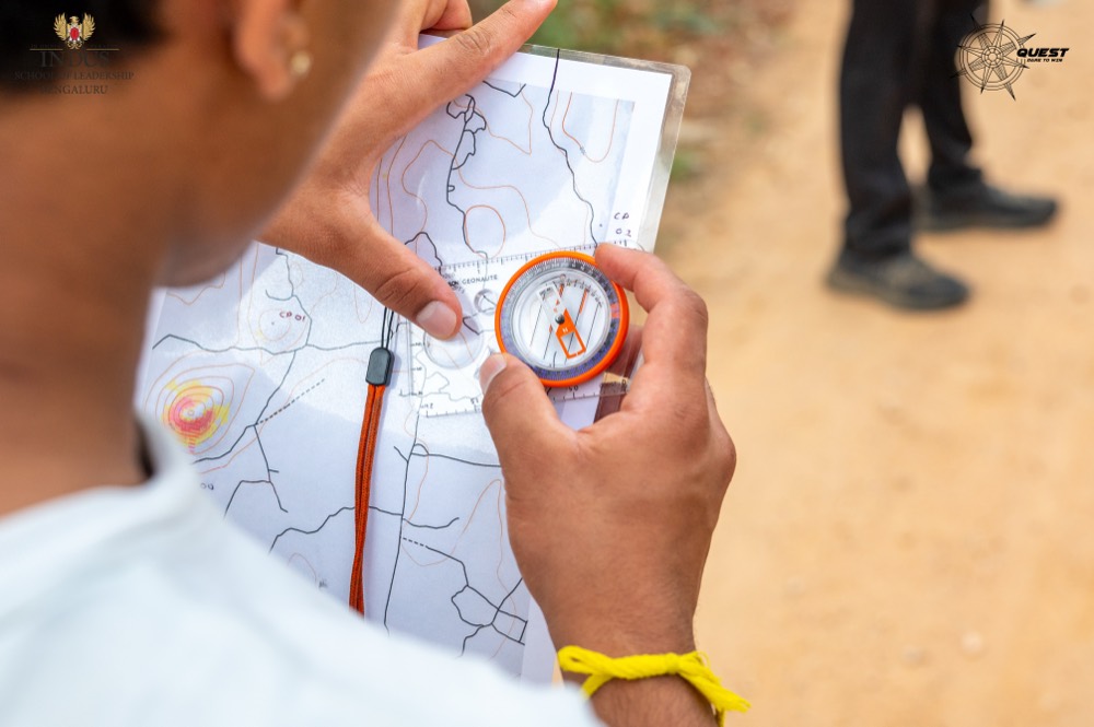 Hands holding a compass over a map