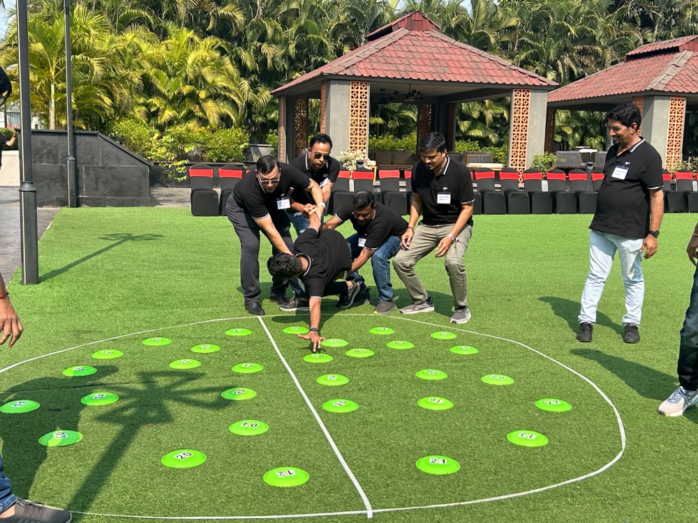A team solving a ground challenge on a marked-out lawn